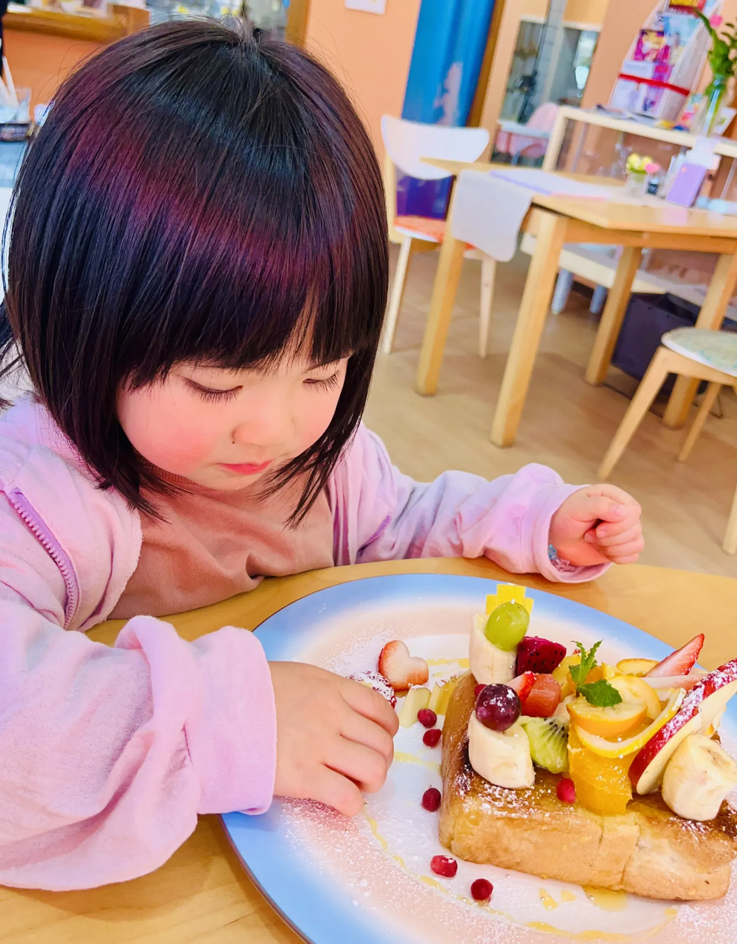おもちゃのお料理を、じっくりと触って遊んでいる女の子